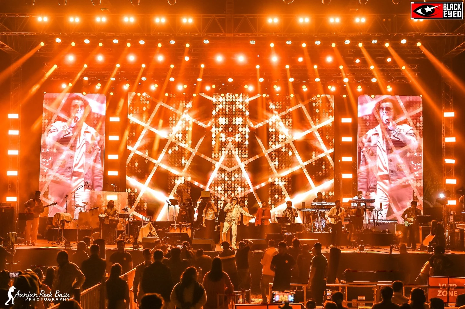 A BlackEyed concert stage illuminated above the crowd
